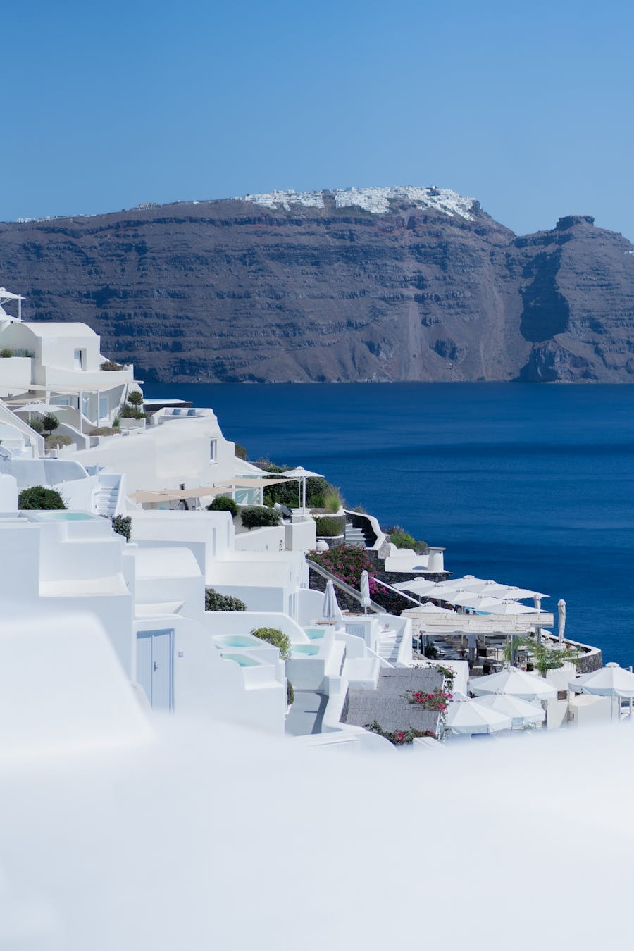 Santorini white houses with Aegean Sea view under clear blue sky